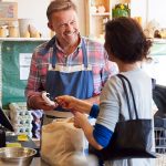 Customer At Checkout Of Organic Farm Shop Making Contactless Payment