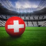 Football in swiss colours in vast football stadium with fans in white svizzera